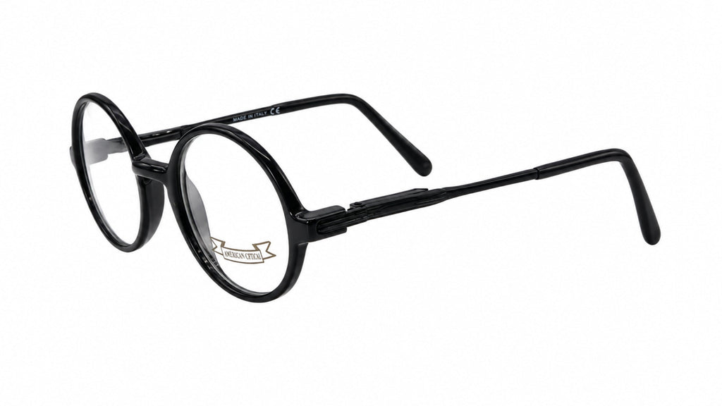 Black round-frame eyeglasses with a glossy finish and clear lenses, shown from a three-quarters angle on a white background.