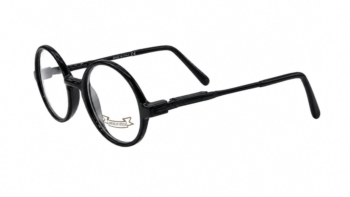 Black round-frame eyeglasses with a glossy finish and clear lenses, shown from a three-quarters angle on a white background.