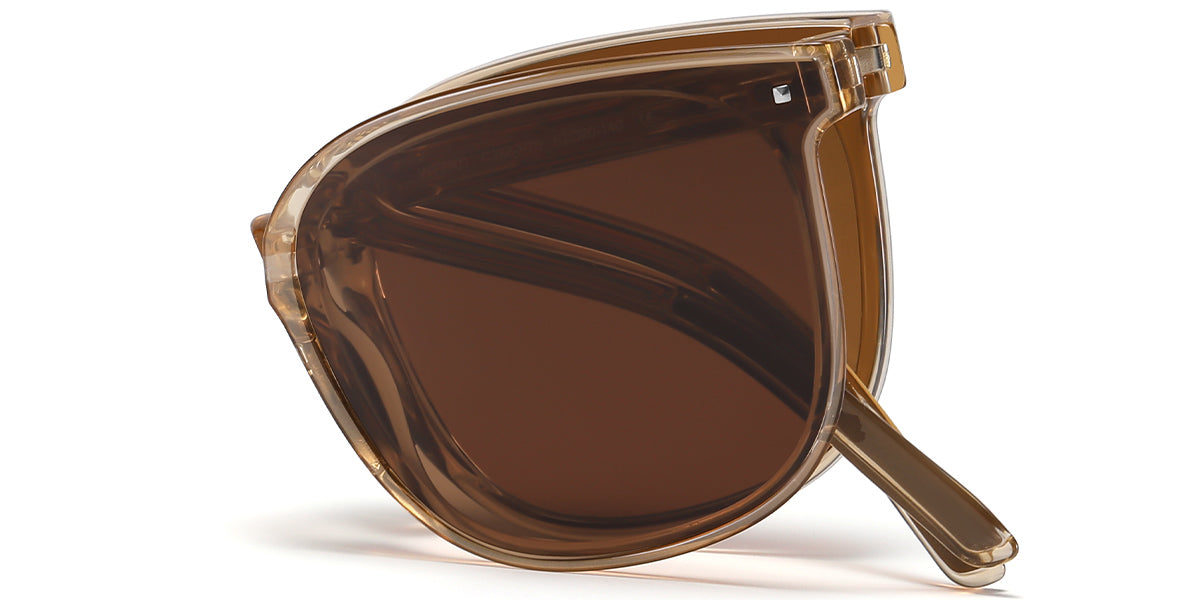 A pair of oversized cat-eye sunglasses with a translucent amber-brown acetate frame and dark brown lenses, shown on a clean white background.