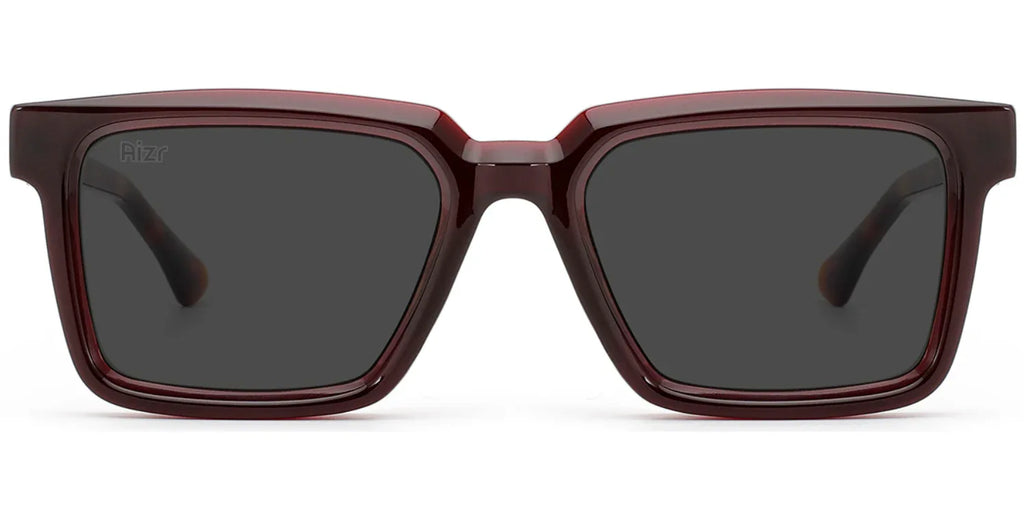 Sunglasses with a maroon frame and dark lenses on a white background