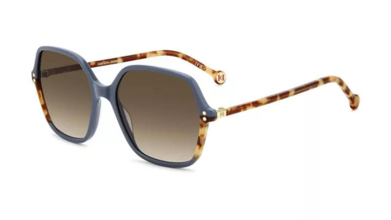 A pair of designer sunglasses featuring a muted blue-gray acetate front frame, brown gradient lenses, and tortoiseshell temples with gold-tone hardware.