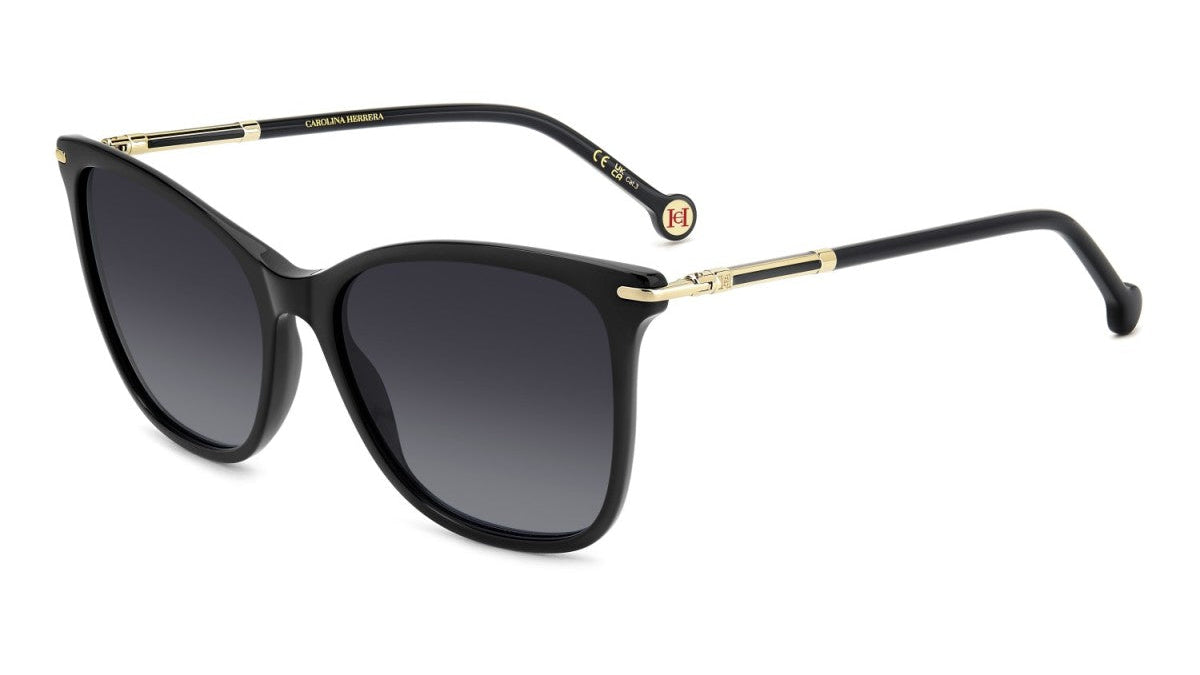A pair of designer sunglasses with a black acetate frame, gradient gray lenses, and gold metal accents on the temples, shown on a plain white background.