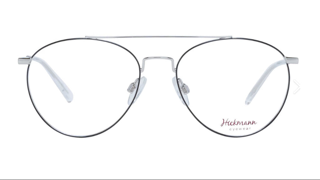 A pair of aviator-style eyeglasses with a thin silver metal frame, clear lenses, and a double bridge, shown against a plain white background. The brand name 'Hickmann Eyewear' is printed in red on the lower right lens.