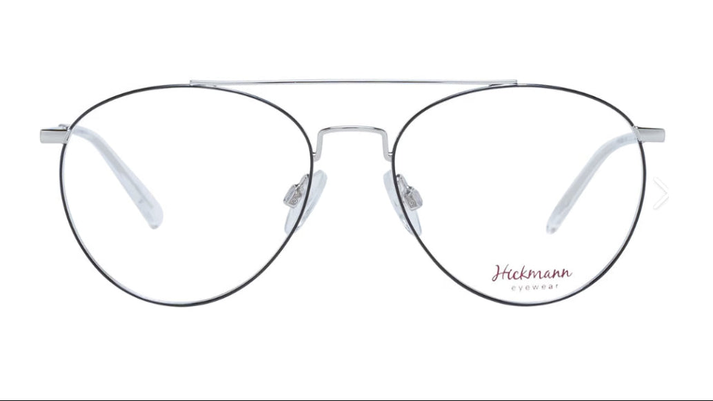 A pair of aviator-style eyeglasses with a thin silver metal frame, clear lenses, and a double bridge, shown against a plain white background. The brand name 'Hickmann Eyewear' is printed in red on the lower right lens.