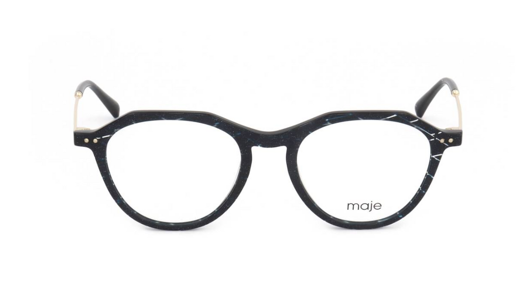 A pair of round eyeglasses with a black and white marbled acetate frame, gold metal hinge accents, and clear lenses. The brand name 'maje' is printed in black on the lower right lens.