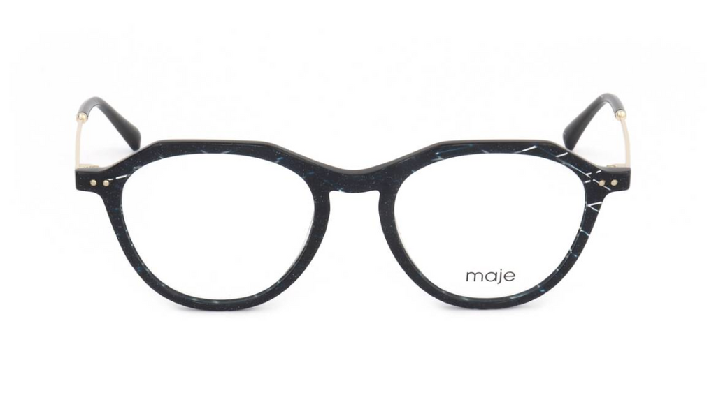 A pair of round eyeglasses with a glossy black and white marbled acetate frame, featuring gold-tone metal rivets and temples, and the brand name 'maje' printed on the lower right lens.
