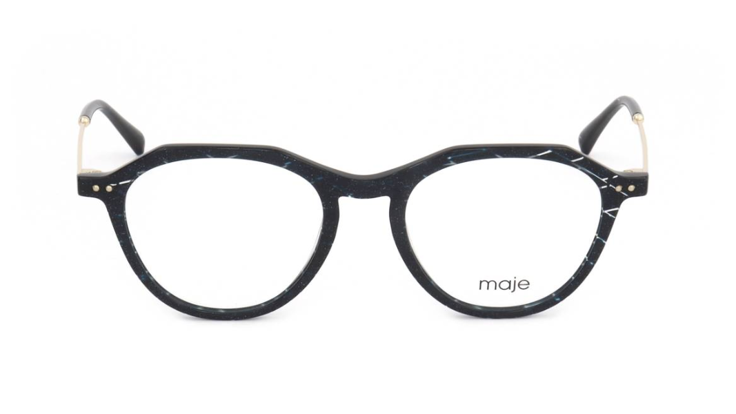 A pair of round eyeglasses with a glossy black and white marbled acetate frame, featuring gold-tone metal rivets and temples, and the brand name 'maje' printed on the lower right lens.