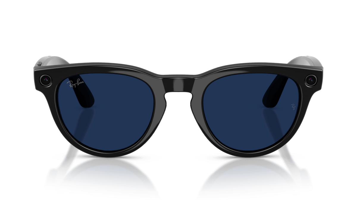Ray-Ban | Meta Headliner Shiny Black -Transitions Gen 2  Black sunglasses with blue lenses on a clear stand against a dark background