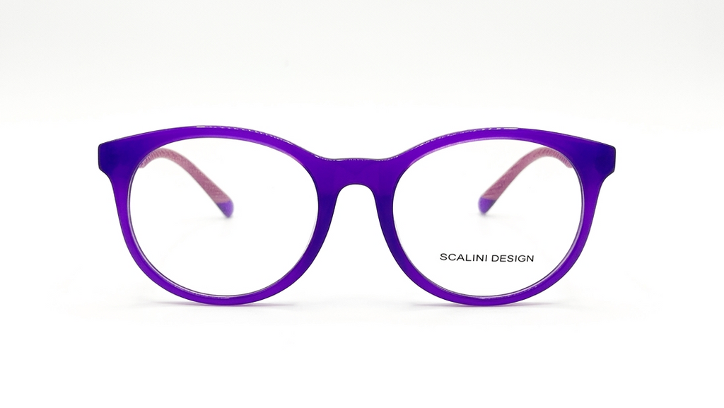 A pair of round cat-eye eyeglasses with a translucent purple frame and pink inner temple tips, shown against a plain white background. The brand name 'SCALINI DESIGN' is printed on the lower right of the lens.