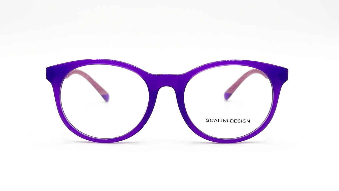 A pair of round cat-eye eyeglasses with a translucent purple frame and pink inner temple tips, shown against a plain white background. The brand name 'SCALINI DESIGN' is printed on the lower right of the lens.