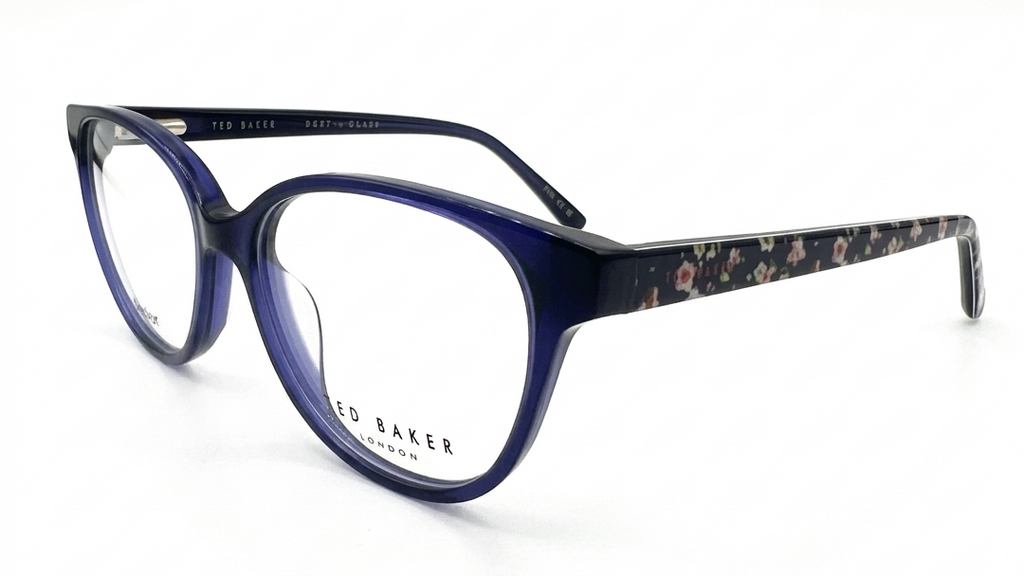 A pair of TED BAKER cat-eye eyeglasses featuring a translucent dark blue front frame and patterned acetate temples with a floral print.