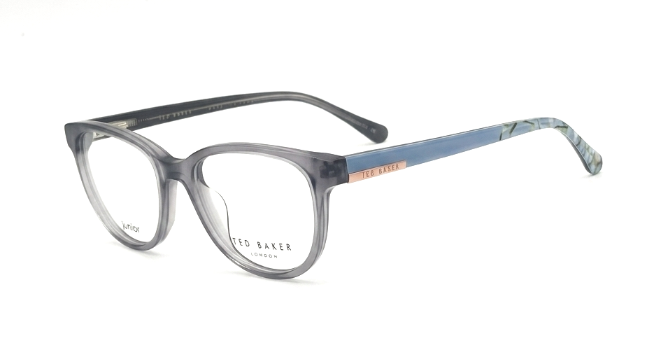 A pair of Ted Baker London eyeglasses featuring a translucent smoky gray acetate frame with a light blue patterned acetate temple arm and a rose gold metal accent on the temple.