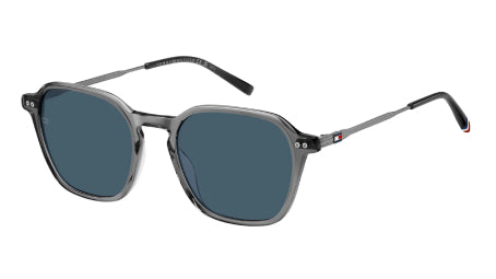 A pair of Tommy Hilfiger sunglasses with a translucent gray acetate frame and dark blue-gray lenses, shown on a plain white background.