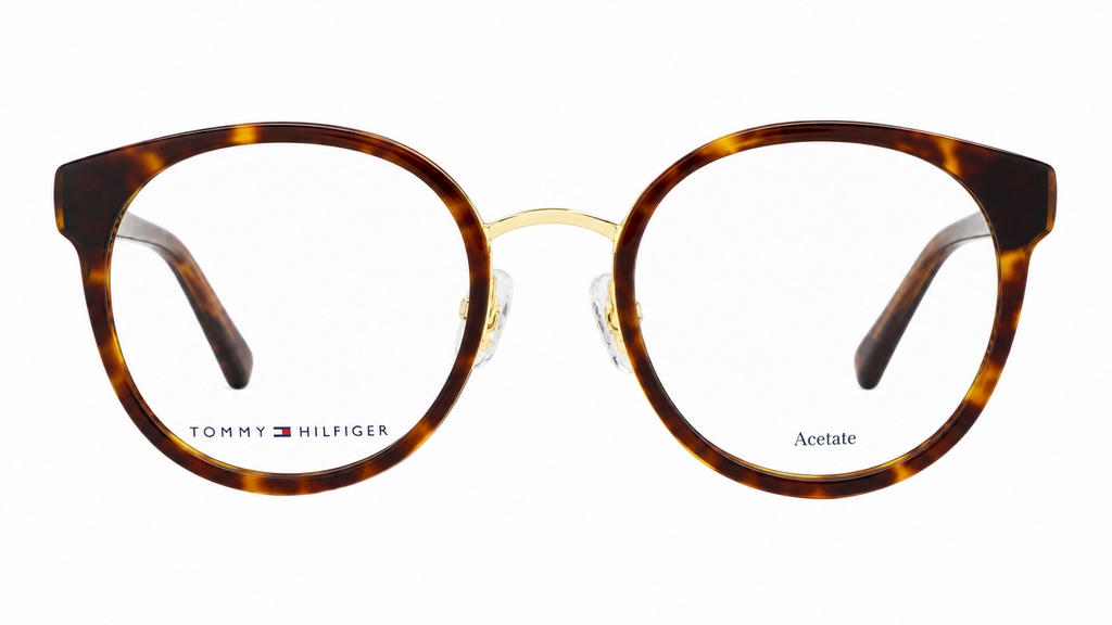 Tommy Hilfiger acetate eyeglasses with a round shape, featuring a brown and amber tortoiseshell pattern on the front frames and gold metal bridge, shown against a plain white background.