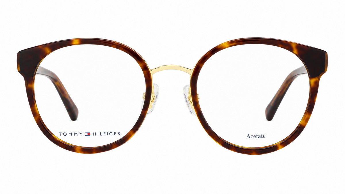 Tommy Hilfiger acetate eyeglasses with a round shape, featuring a brown and amber tortoiseshell pattern on the front frames and gold metal bridge, shown against a plain white background.