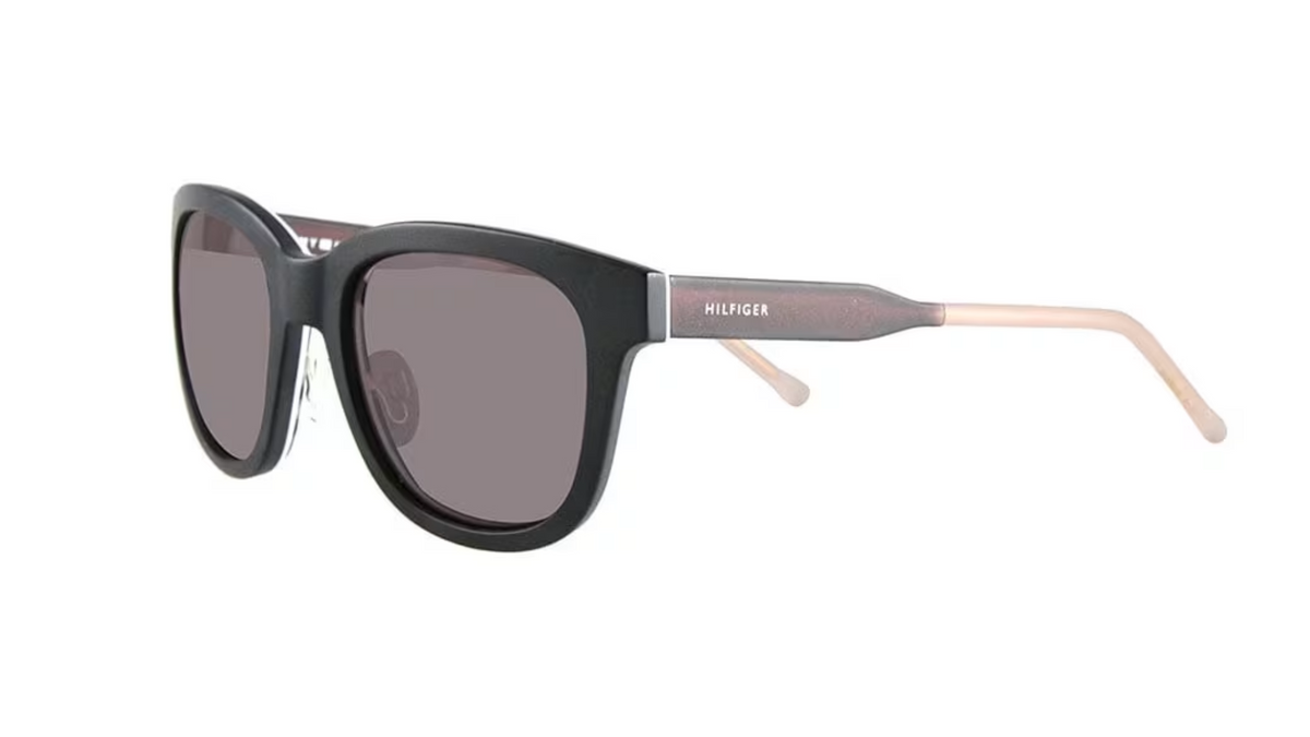 A pair of sunglasses with a glossy black front frame, dark gray lenses, and light pinkish-beige temples. The brand name 'MILFINGER' is printed in white on the temple.