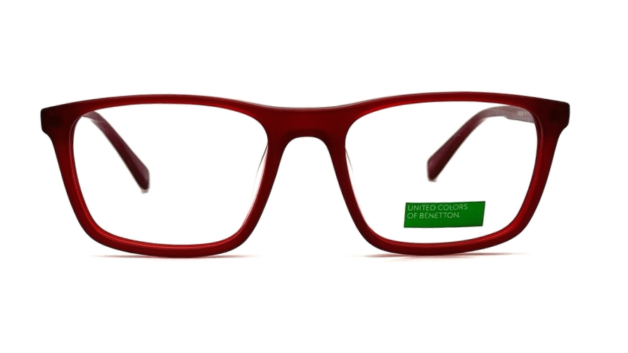 A pair of square-framed eyeglasses with a translucent dark red acetate frame and clear lenses, shown against a plain white background. A small green 'LIMITED COLOR CORRECTION' sticker is visible on the lower right lens.
